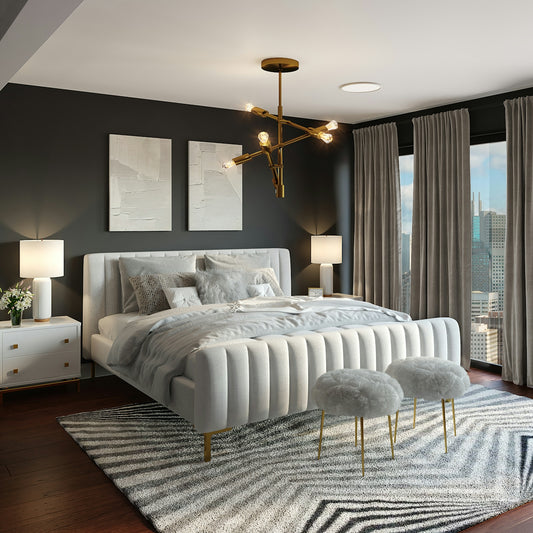 A modern bedroom with a white upholstered bed, gold chandelier, and city view